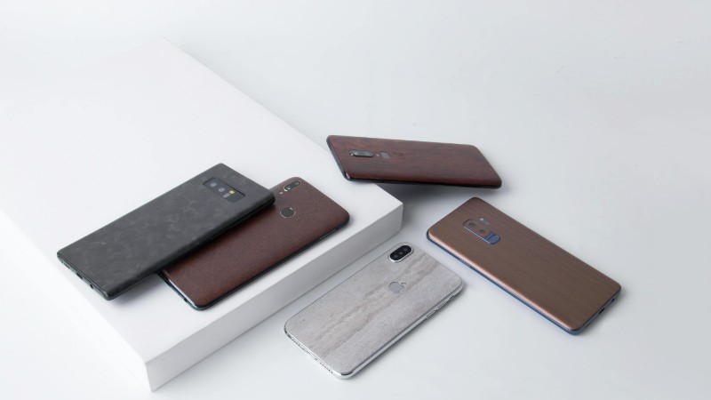 Close-up of various smartphones with stylish covers on a minimalistic white background., tags: geräte - pexel