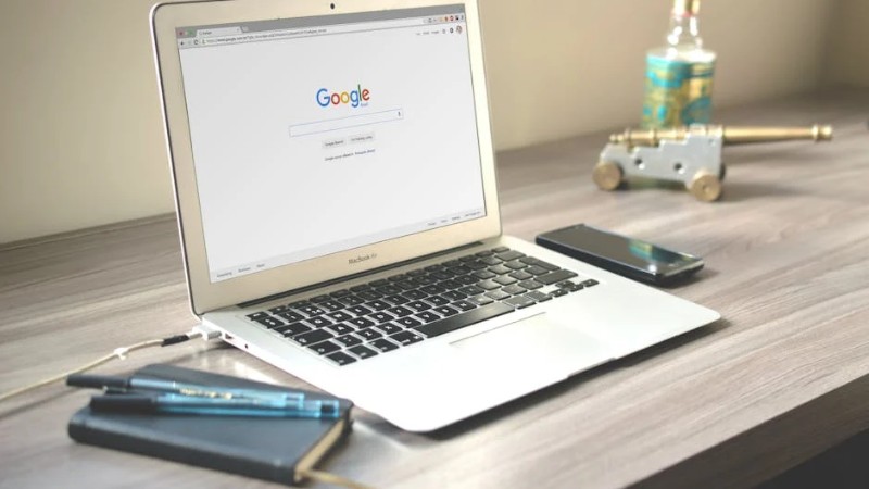 A neat workspace featuring a laptop displaying Google search, a smartphone, and a notebook on a wooden desk. - A neat workspace featuring a laptop displaying Google search, a smartphone, and a notebook on a wooden desk., tags: für produktivität modernen - pexel