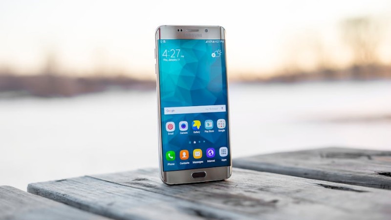 Samsung smartphone placed on a wooden surface outdoors during sunset. - Samsung smartphone placed on a wooden surface outdoors during sunset., tags: im sich - pexel